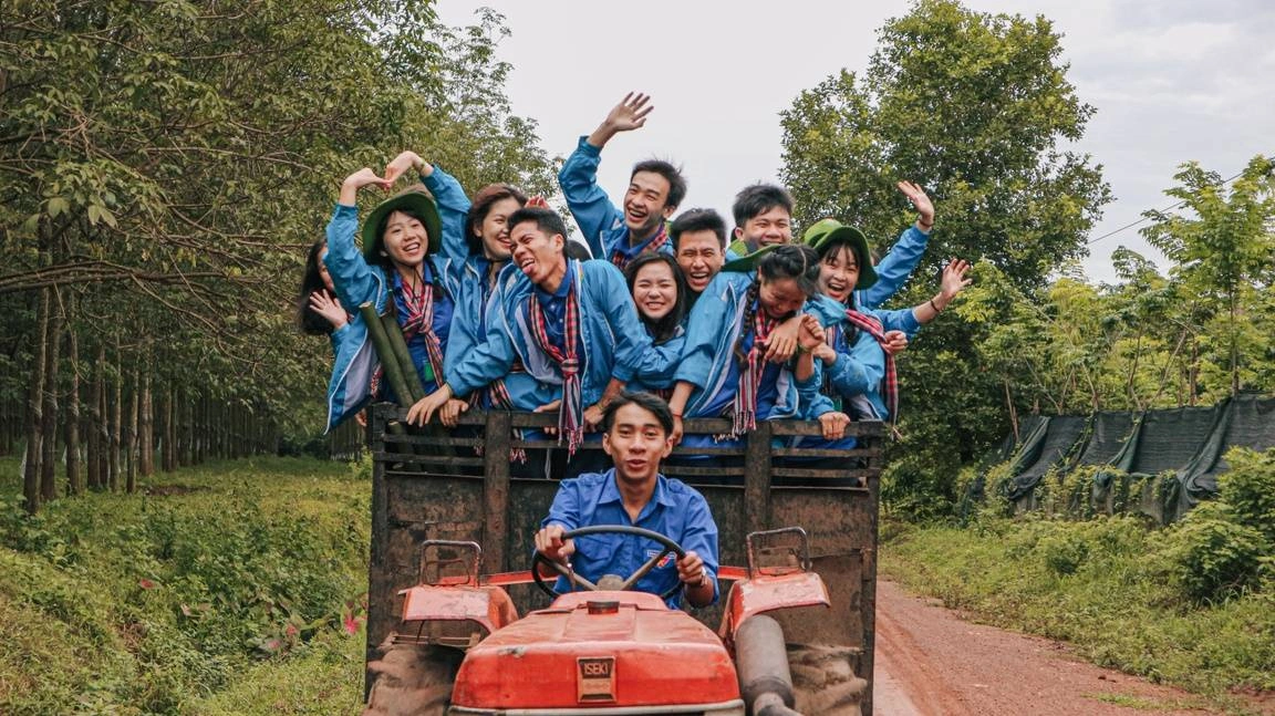 Grupo de jovens asiáticos se divertindo em um trator
