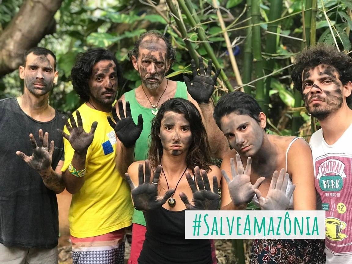 A group of people covered in mud pose for a photograph.