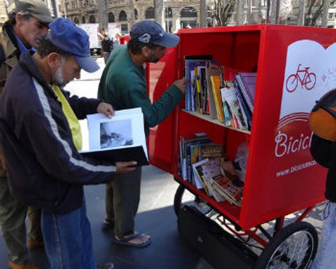 Group of people getting books from a portable library.