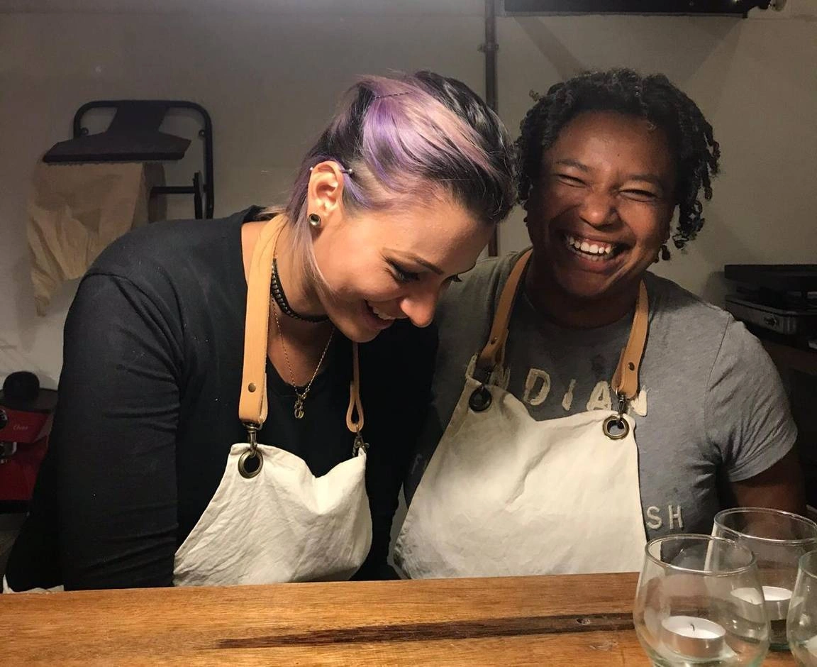 Dos mujeres riendo mientras cocinan