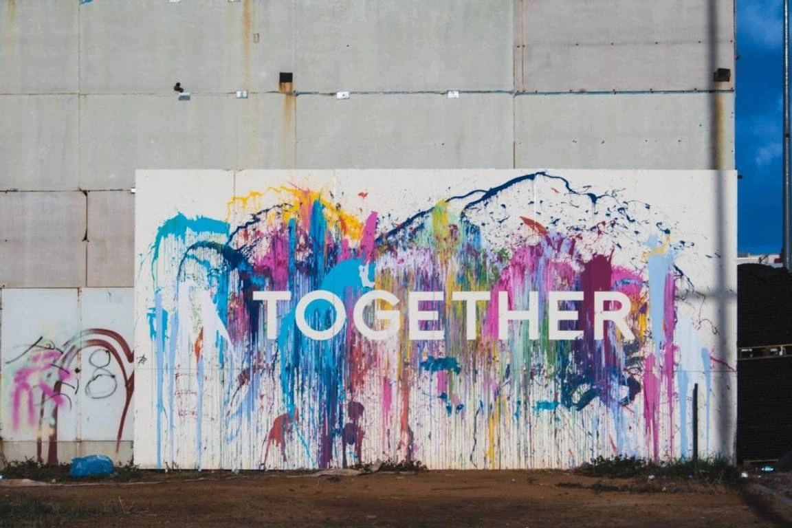 Mural colorido com a palavra "juntos" em inglês destacada