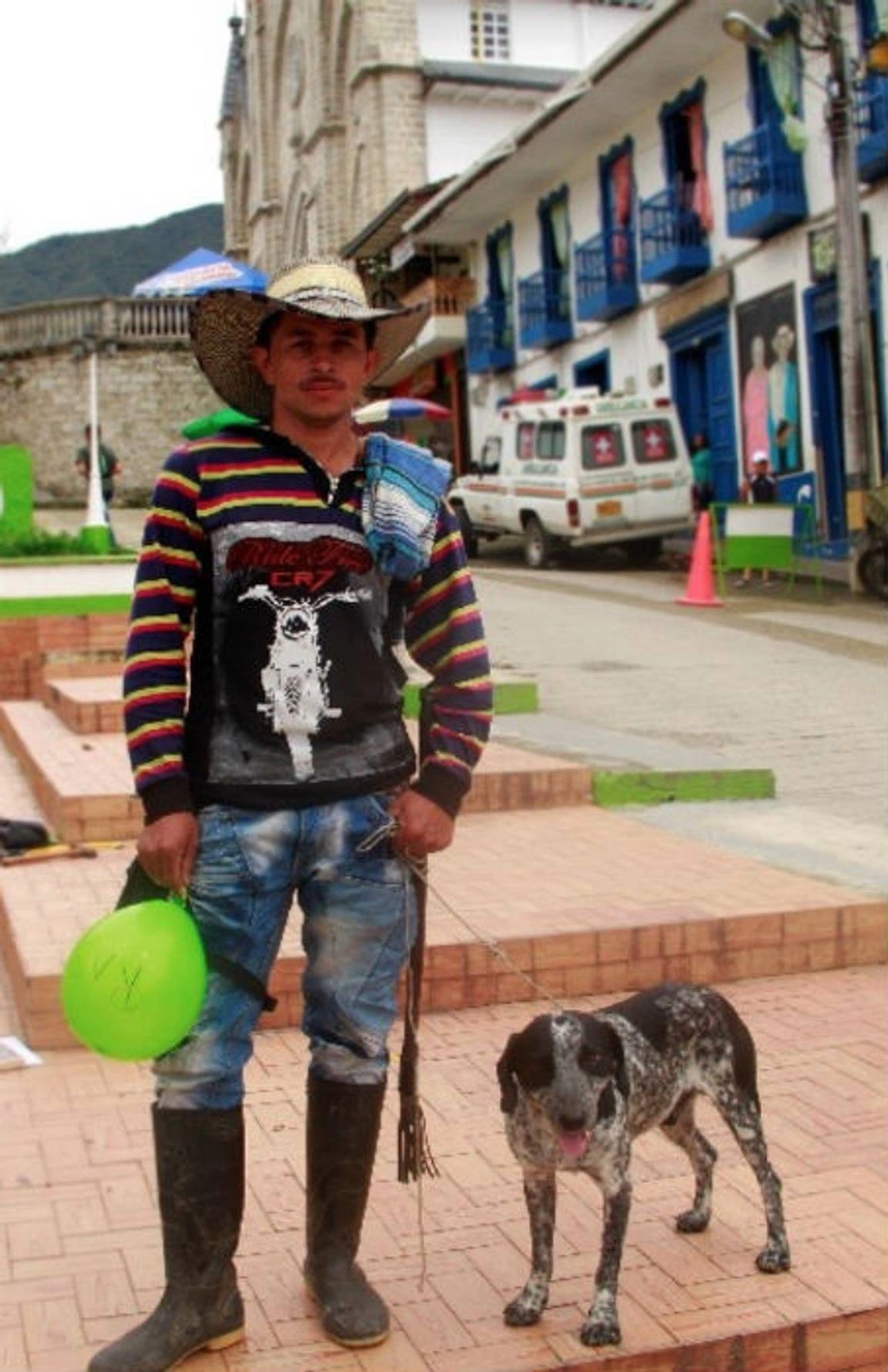Jóven colombiano junto a un perrito en un pueblo