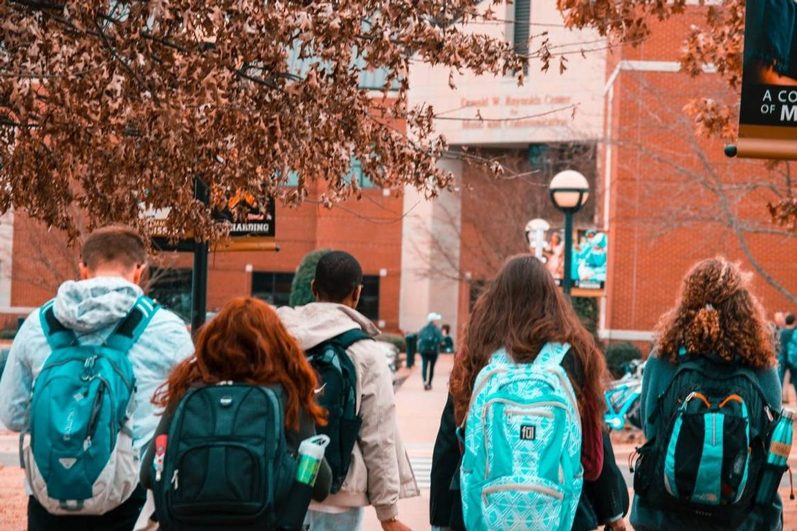 Group of students with backpacks walking through campus.
