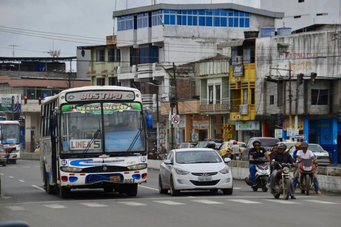 Imagem urbana de rua com ônibus e carros em Quito