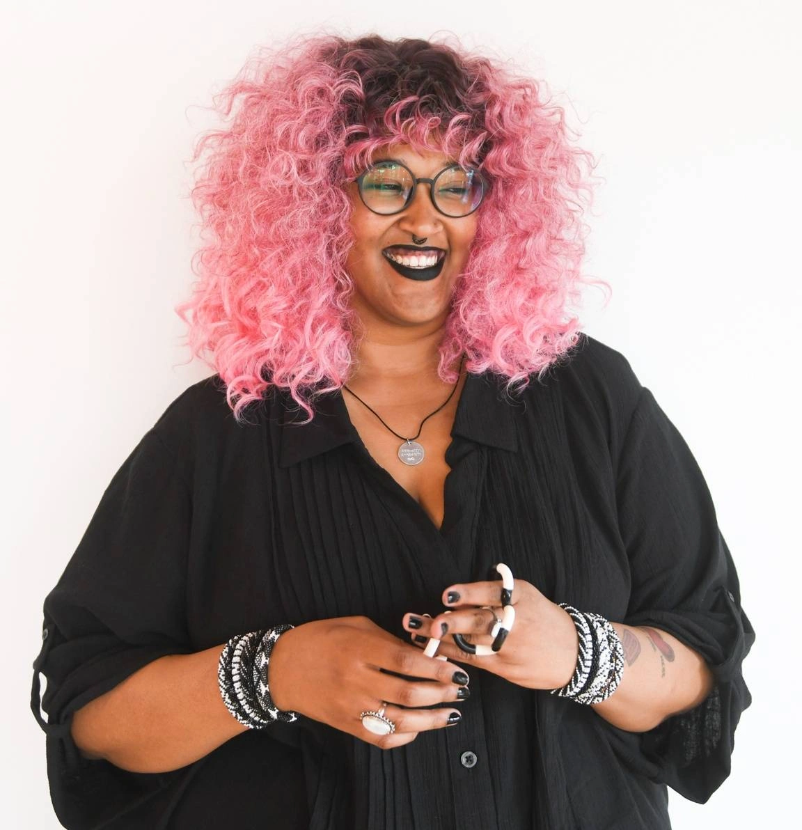 Woman with pink hair smiling.