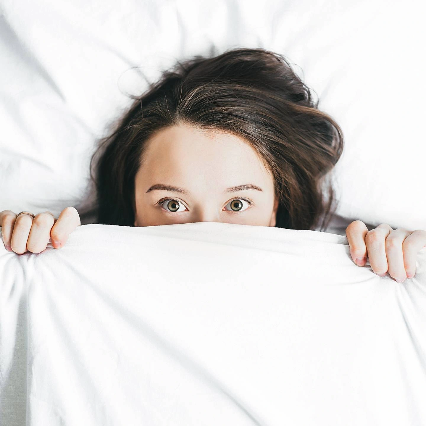 A women hiding in the covers.