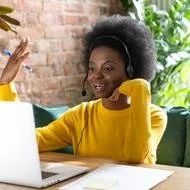 A Black woman noting employee benefits during a salary negotiation.