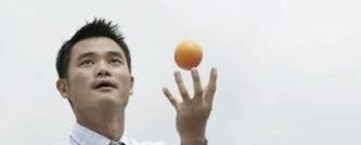 A man tosses an orange into the air.