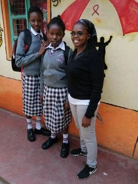 Our founder Margret Standing with two school girls