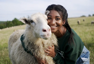 Farm Sanctuary staff, Arianna Duncan, poses with Adriano Sheep