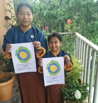 Two children pose with the Idealist logo in Bhutan.