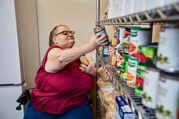 Woman stocking canned foods on shelves