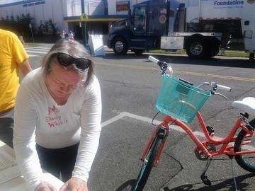 Sally helps fill out a tag for bike parking at an event