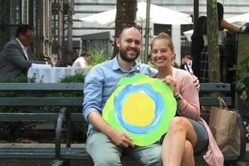 A couple at a bench with the Idealist logo between them.