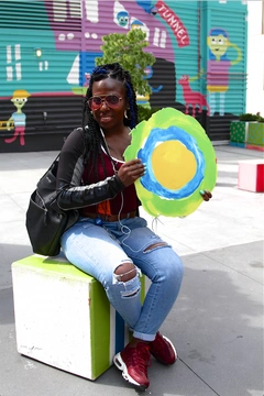 Someone wearing a backpack poses with the Idealist logo.