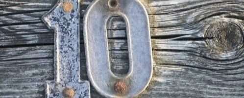 A metal design of the number 10 on a piece of wood.