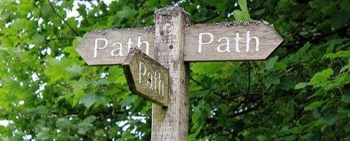 A photograph of a trail sign marked "Path" in three different direfction, with a big tree behind it.