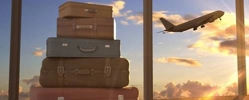 A pile of suitcases with a plane taking off.