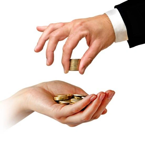 A hand placing coins in another hand