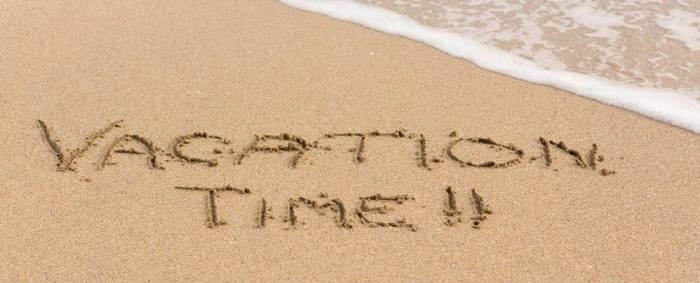 The beach with 'Vacation Time' written on the sand.