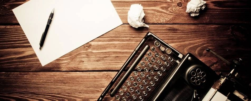 A typewriter and a piece of paper on a desk.