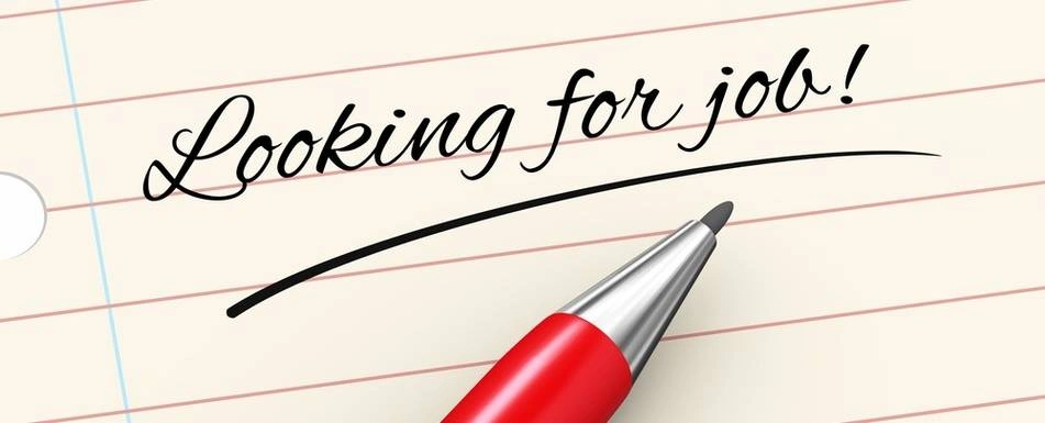 A close up of the phrase "Looking for a job" on a piece of paper.