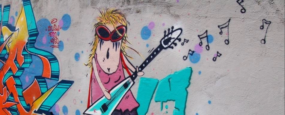 Street art of a woman playing the guitar.