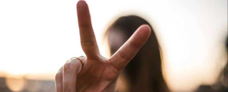 A person holding up a peace sign with their fingers.