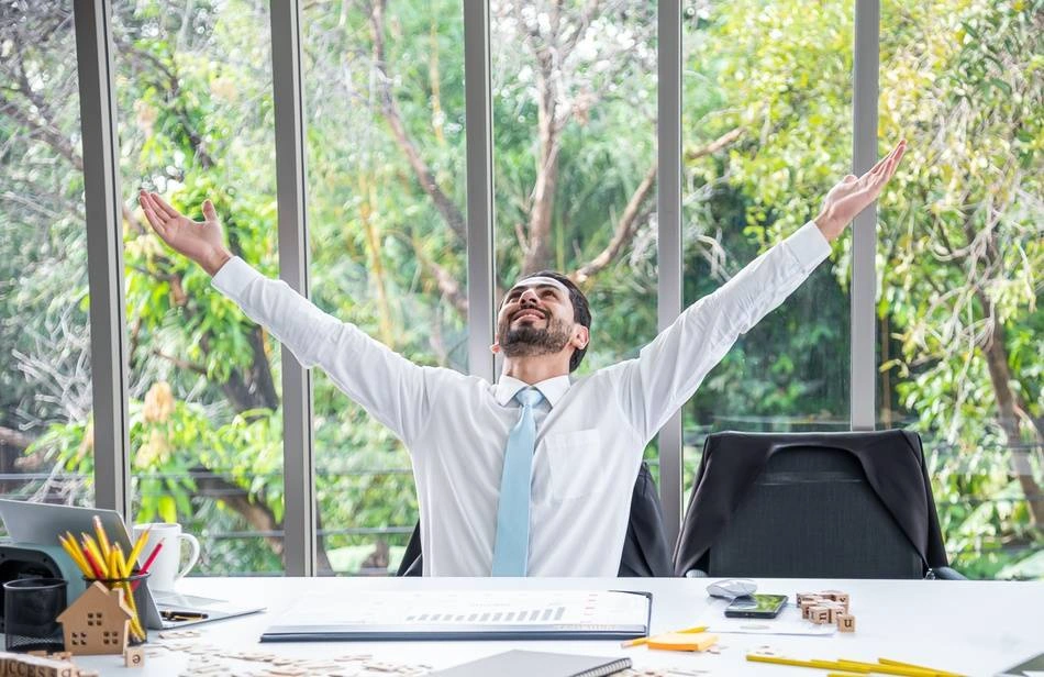 A businessman celebrates a successful performance review at work.
