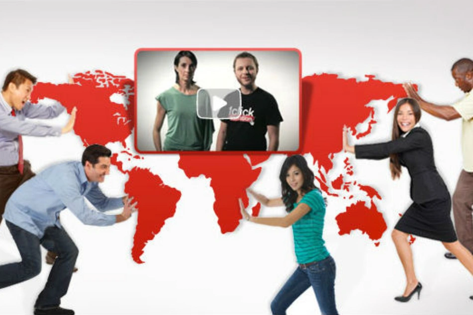 Fotomontaje de una pantalla con un video y varias personas empujando partes del mapa del mundo como tratando de unirlo