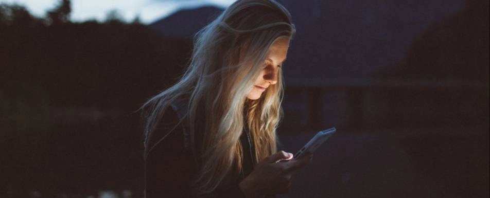 A woman looking down at her phone.