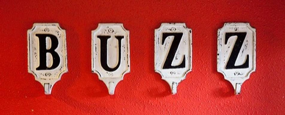 Coat hooks that spell out the word, "Buzz."