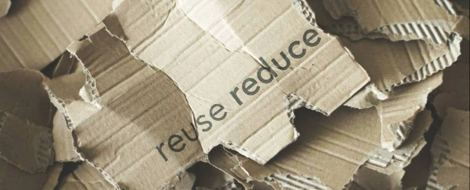 Broken up cardboard that says reuse and reduce on it.