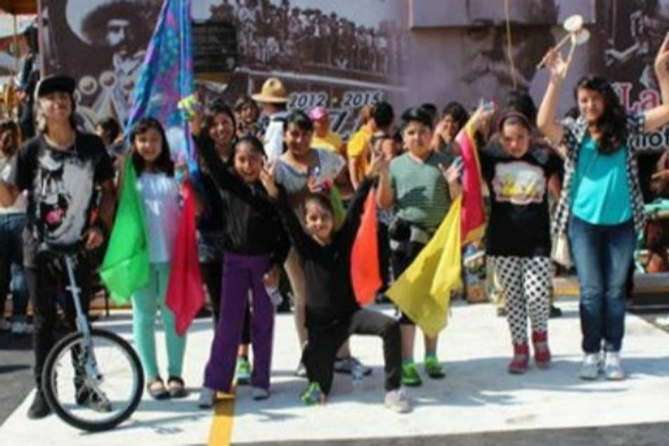 Un grupo de niños y niñas con banderas de colores