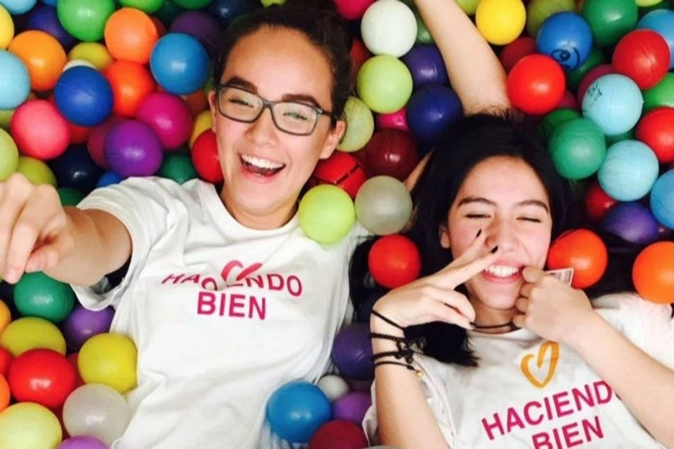 Two volunteers on their backs in a ball pit.