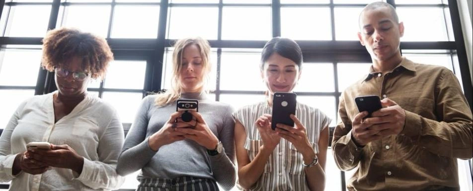 A group of people looking at their phones.