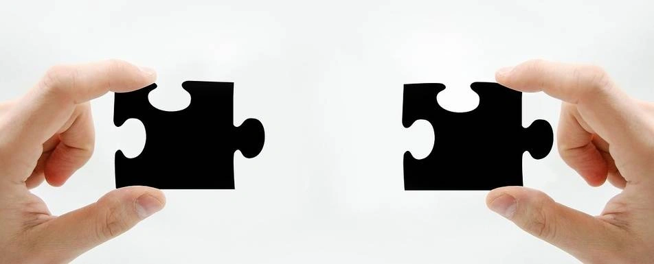 Two hands holding a puzzle piece.