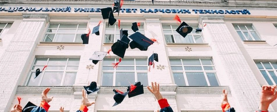 A group of students throwing their graduation caps in the air.