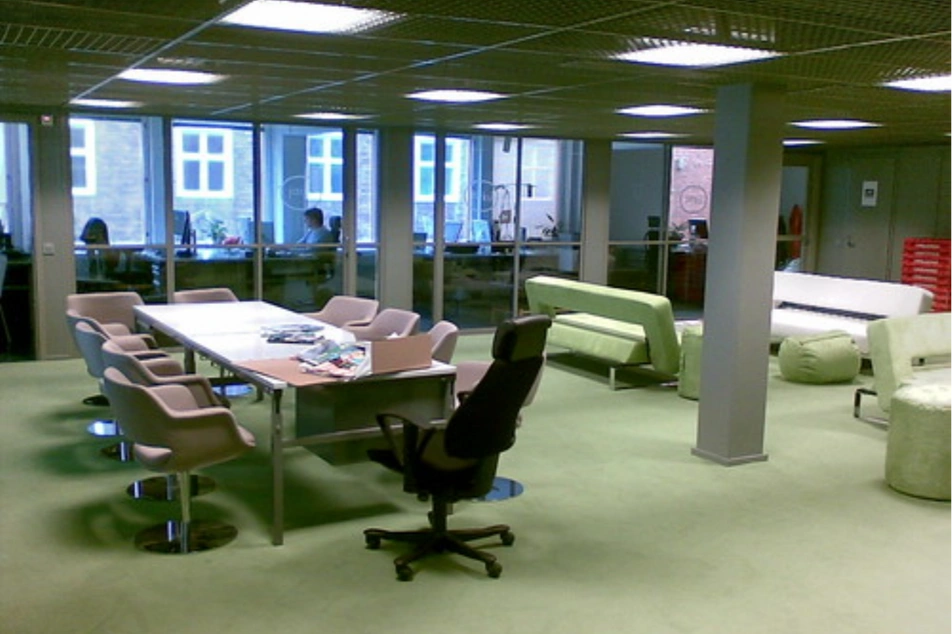 Imagen de una oficina grande con poca gente trabajando