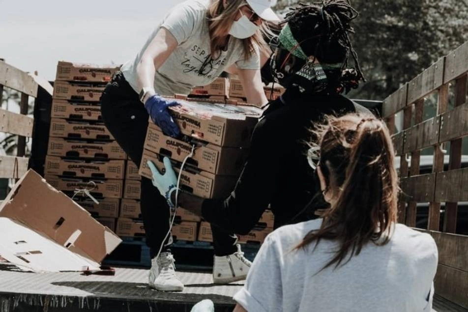 Voluntarios descargando donaciones de un camión