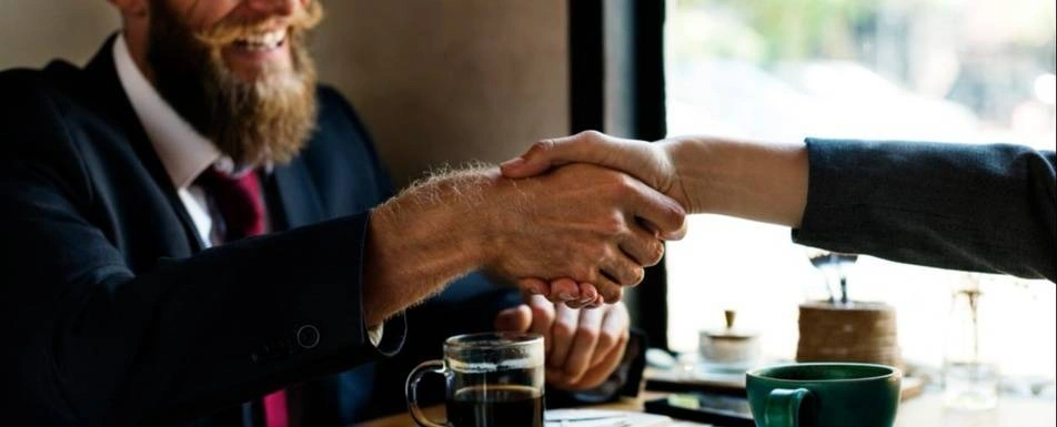 A handshake over a table.