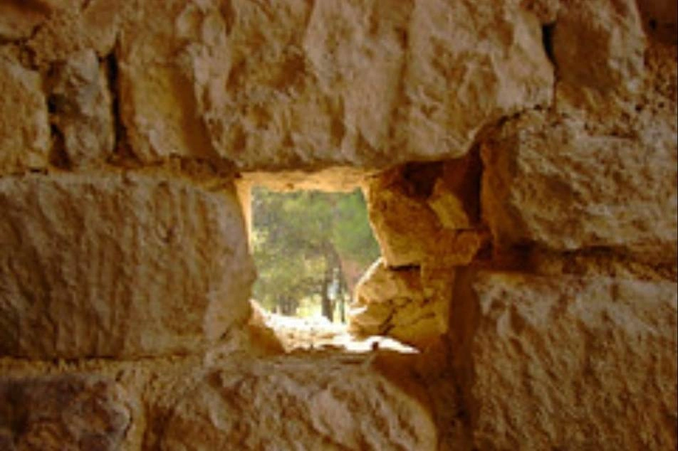 Una pared de piedra con una ventana