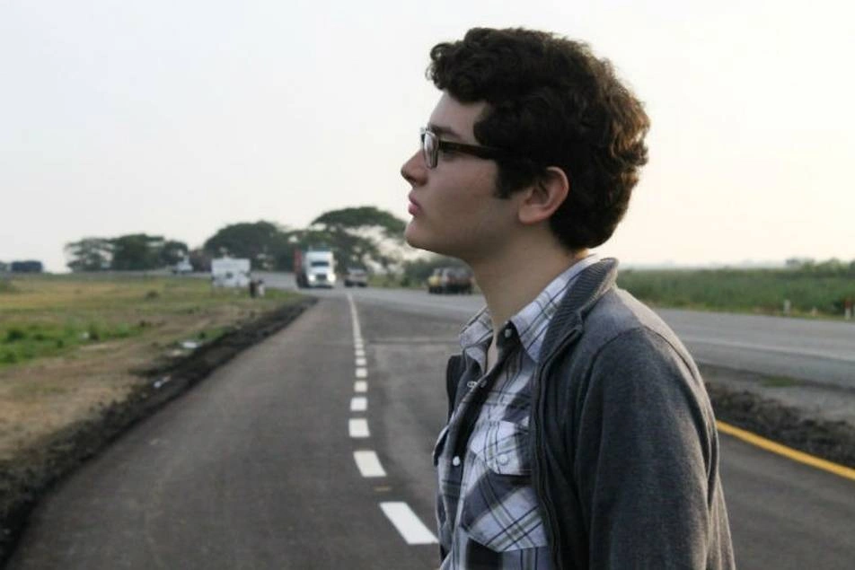 chico mirando al horizonte en una carretera