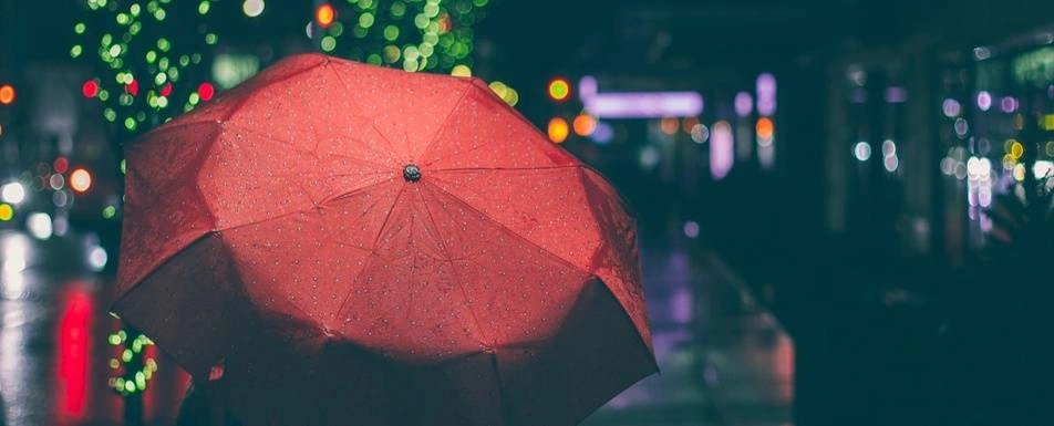 A red umbrella on a rainy night.