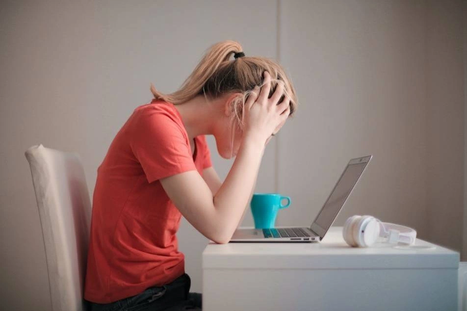 mujer agobiada frente a la computadora