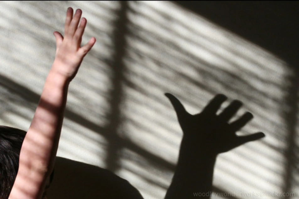 Una mano abierta haciendo una sombra contra la pared