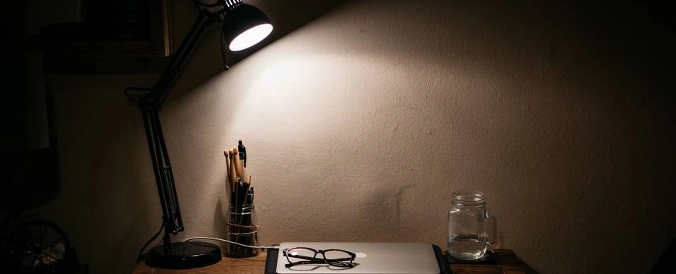 desk at night with laptop  and desk lamp on