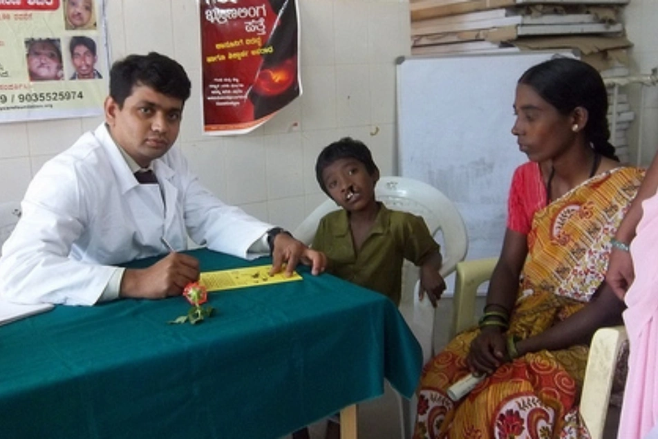 Un doctor en la India atendiendo a un niño con labio leporino
