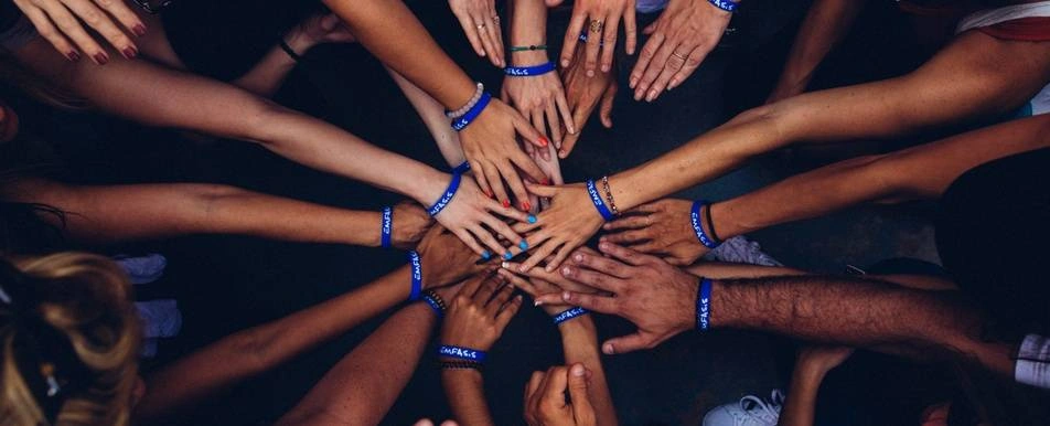 volunteers putting hands in a circle