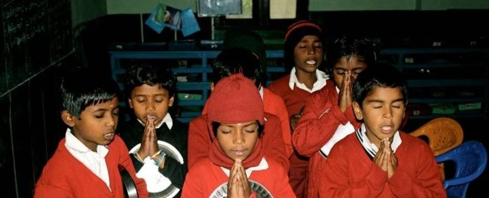 A group of children praying.